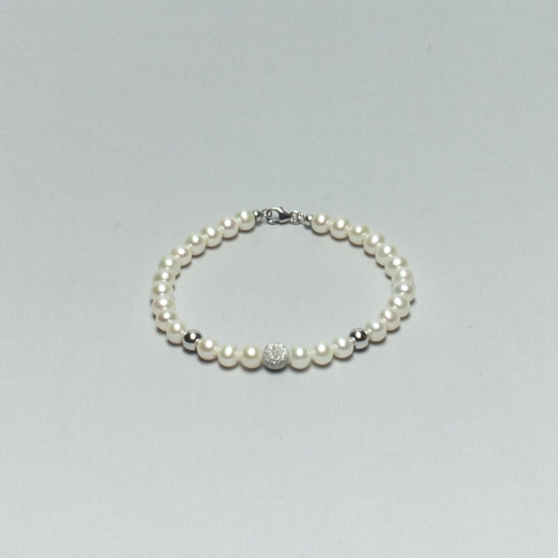 Bracciale di Perle Bianche d'Acqua Dolce montato in Oro bianco con una sfera diamantata e due lisce, con coppiglie